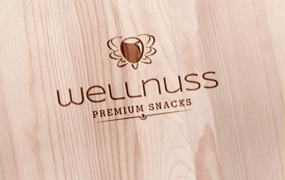 Wellnuss – Logo Design & Markenprägung Wellnuss Logo als Holzprägung – edles Branding-Design mit natürlicher Materialanmutung für Premium Snacks.